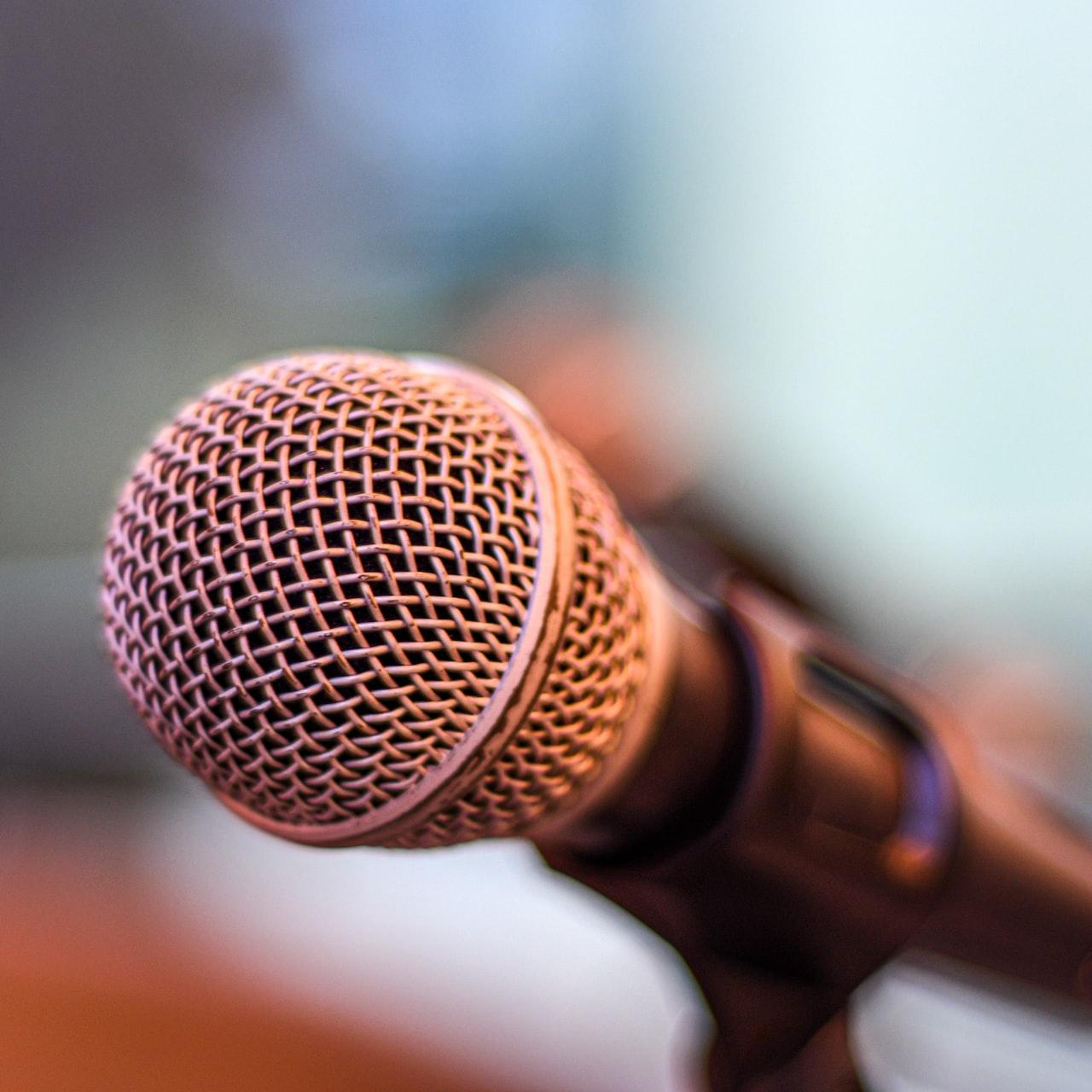 grey microphone on brown wooden stand